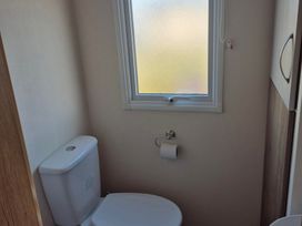 A bathroom with a toilet and window at Unity Beach - Abi Ryedale Burnham-on-Sea