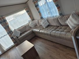 A living room with a sofa and coffee table at Unity Beach - Abi Ryedale in Burnham-on-Sea