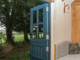 A door leading outside with a view of greenery at Ridden Brake shepherds hut Yelverton