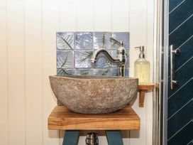 A sink with faucet and soap dispenser in the bathroom at Ridden Brake shepherds hut Yelverton