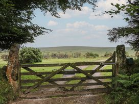 A wooden gate leading to a grassy field at Ridden Brake shepherds hut Yelverton