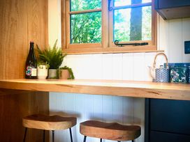 A kitchen with a counter, plants, and a window at Goldcrest in Postbridge