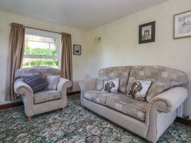 A living room with a sofa and armchair at Robin Hood Farmhouse in Keswick