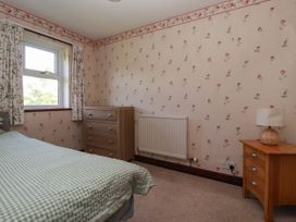 A bedroom with a bed, dresser, window, and lamp at Robin Hood Farmhouse in Keswick