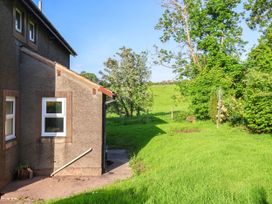 An outdoor area with a building, grass, and trees at Robin Hood Farmhouse in Keswick