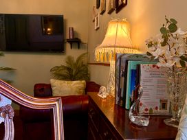 A living room with a lamp and books on a table at Downton I in Alnwick