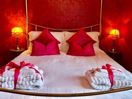 A bedroom with a bed, pillows, and towels at Downton I in Alnwick