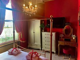 A bedroom with a bed and a chandelier at Downton I in Alnwick