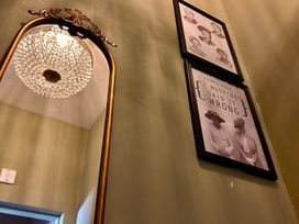 A mirror and framed photographs on the wall at Downton I in Alnwick