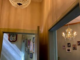 A hallway with a chandelier and framed pictures at Downton I Alnwick