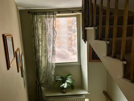 A staircase with a window and pictures at Downton I, Alnwick