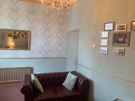 A living room with a sofa and mirror at Downton I in Alnwick