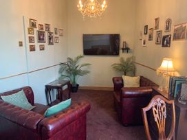 A living room with a television and leather sofas at Downton I in Alnwick