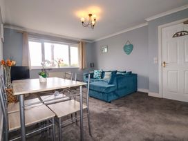 A living room with a table and chairs and a sofa at Treetops in Par
