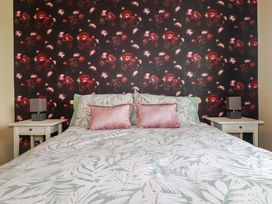A bedroom with a bed and bedside tables at Treetops in Par