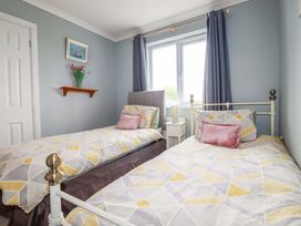 A bedroom with two beds and a plant on a shelf at Treetops in Par