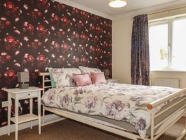 A bedroom with a bed and bedside table at Treetops St Blazey