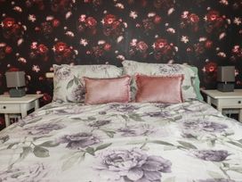 A bedroom with a bed and bedside tables at Treetops St Blazey