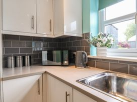 A kitchen with a microwave, kettle, and sink at Frome View Wool