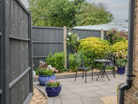 A garden with potted plants and a patio table and chairs at Frome View in Wool
