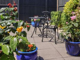 A garden with a table and chairs surrounded by flower pots at Frome View in Wool