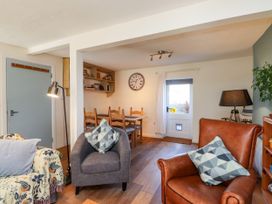 A living room with a sofa and armchair at Scoops’ Nook in Caernarfon