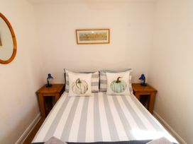 A bedroom with a bed and nightstands at Scoops’ Nook, Caernarfon