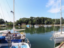 A view of boats on water with trees in the background at Scoops’ Nook, Caernarfon