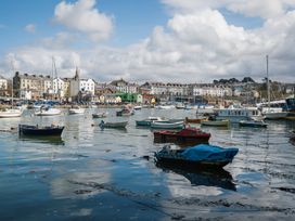 A harbor with boats and buildings at Scoops’ Nook in Caernarfon