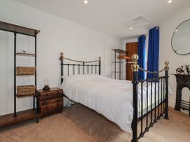 A bedroom with a bed and shelves at 31 Tregoney Hill Mevagissey