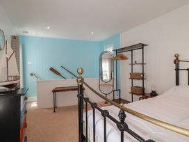 A bedroom with a bed and a dressing mirror at 31 Tregoney Hill in Mevagissey