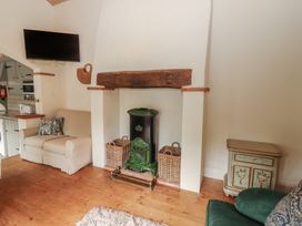 A living room with a sofa and television at The Coach House Cottage BALLYCOMMON