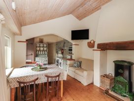 A kitchen with a table and chairs at The Coach House Cottage BALLYCOMMON