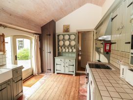 A kitchen with a sink, cupboards, and plates on display at The Coach House Cottage BALLYCOMMON