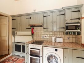 A kitchen with cabinets, appliances and countertop at The Coach House Cottage BALLYCOMMON