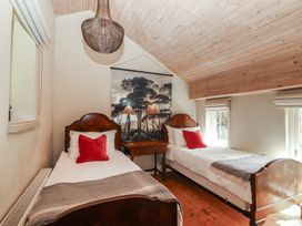 A bedroom with two beds and a table at The Coach House Cottage BALLYCOMMON