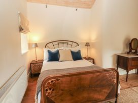 A bedroom with a bed and nightstands at The Coach House Cottage BALLYCOMMON