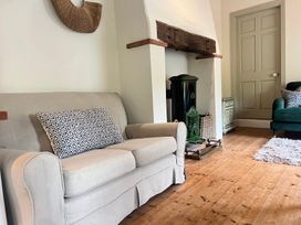 A living room with a sofa and fireplace at The Coach House Cottage Ballycommon