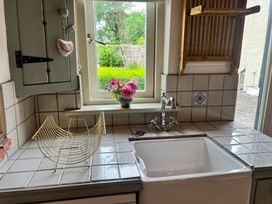 A kitchen with a sink and a flower vase at The Coach House Cottage Ballycommon