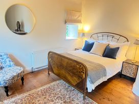A bedroom with a bed, bedside tables, and a chair at The Coach House Cottage in Ballycommon