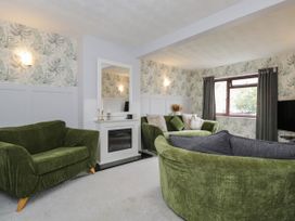 A living room with green sofas and a mirror at 1 Stanway Road