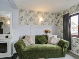 A living room with a green couch and decorative pillows at 1 Stanway Road