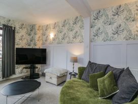 A living room with a TV, sofa, and lamp at 1 Stanway Road