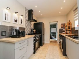 A kitchen with a stove and refrigerator at 1 Stanway Road