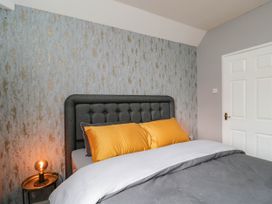 A bedroom with a bed and bedside table at 1 Stanway Road
