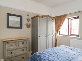 A bedroom with a wardrobe, mirror, and chest of drawers at 1 Stanway Road