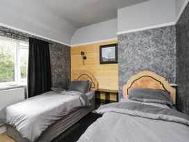A bedroom with twin beds and a mirror at 1 Stanway Road