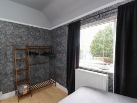 A bedroom with a clothing rack and window at 1 Stanway Road