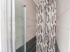A shower with tile walls and a glass door at 1 Stanway Road