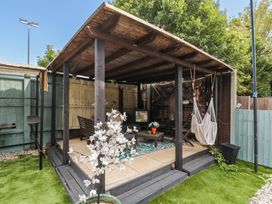A garden shelter with a hammock and seating area at 1 Stanway Road